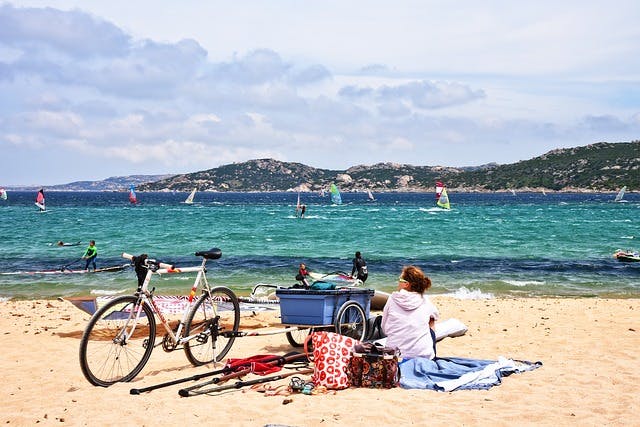 beach with windsurfers and a bicycle